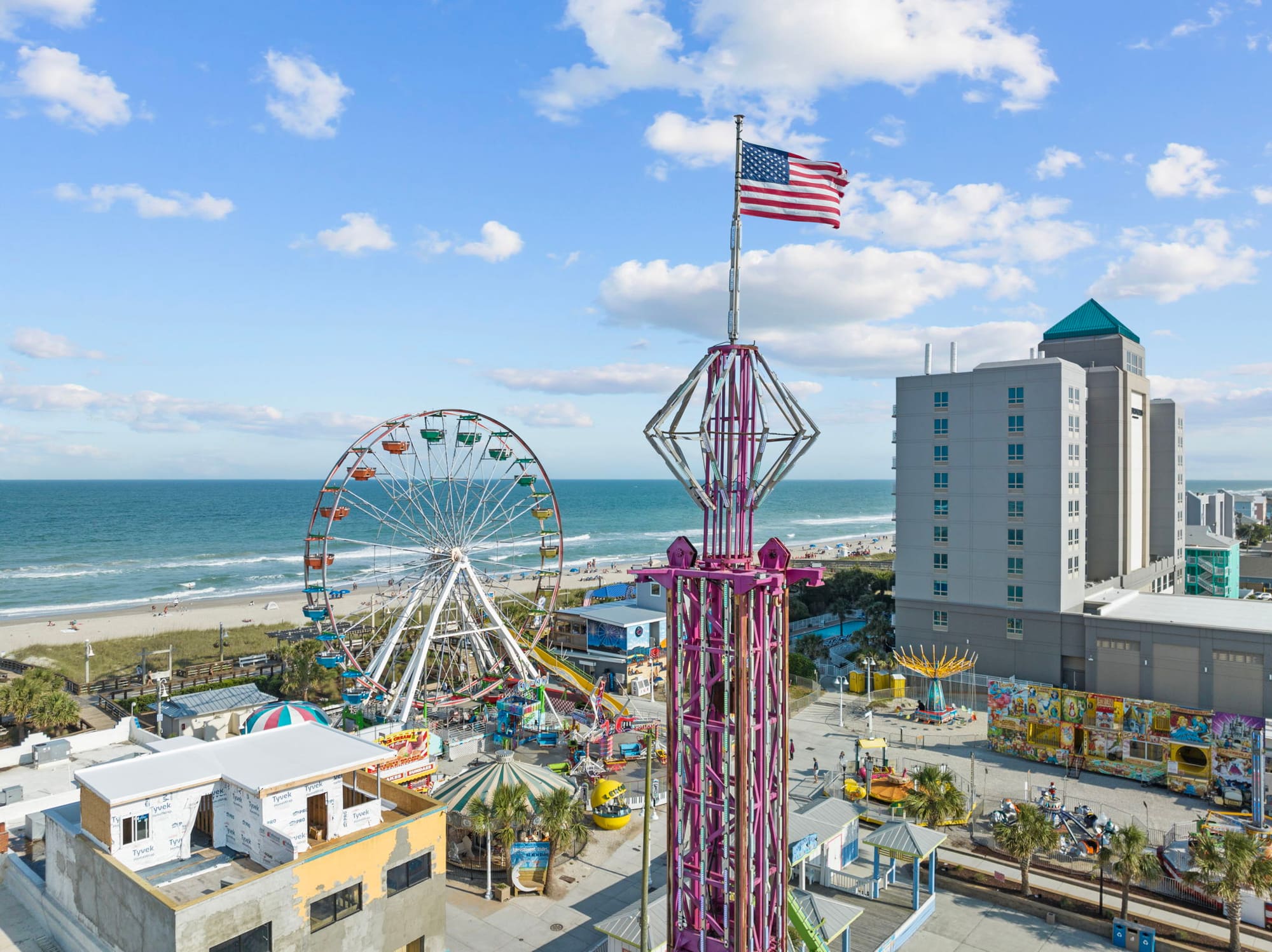 Rides and the Ferris wheel by the ocean at the Carolina Beach Boardwalk