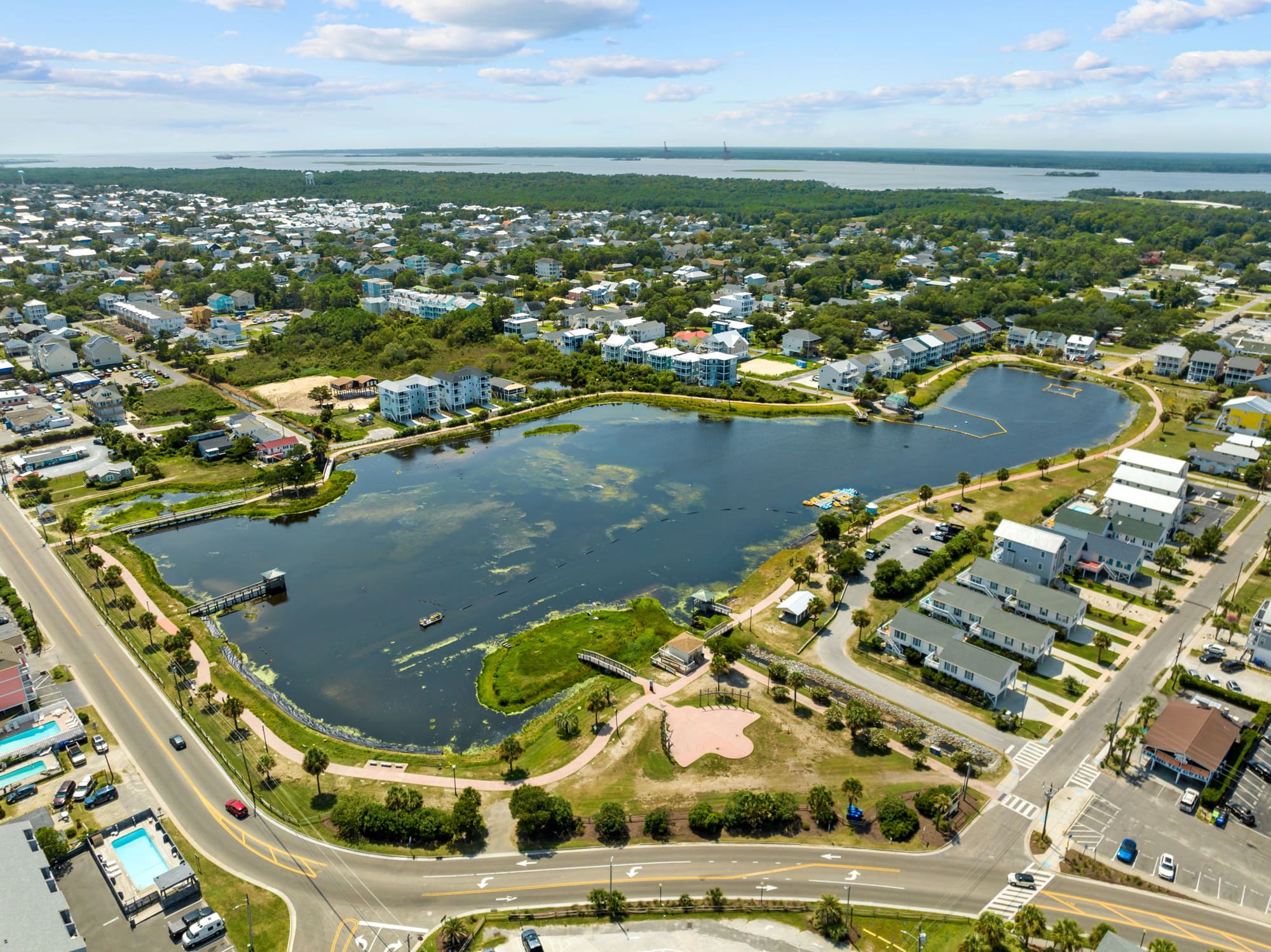 Aerial view of a Carolina Beach neighborhood of vacation homes around a pond